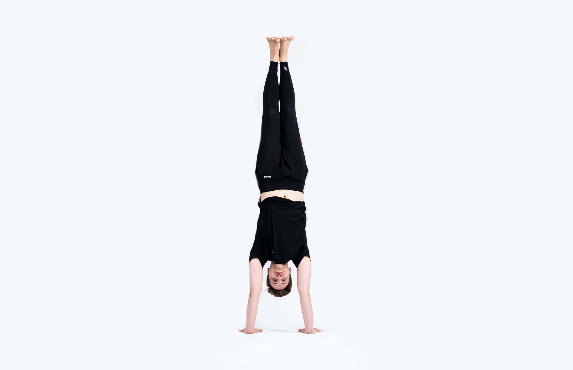 A person inverted into Adho Mukha Vrksasana (Handstand)