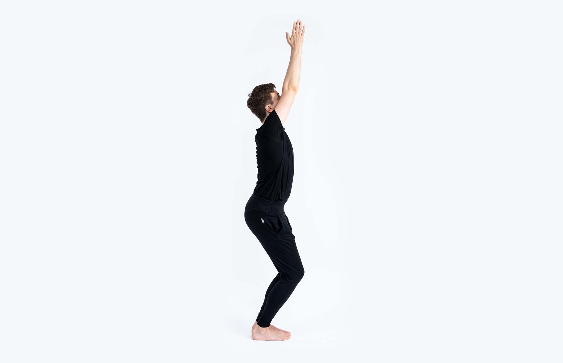 A person reaching up in Uttkatasana (Chair Pose)