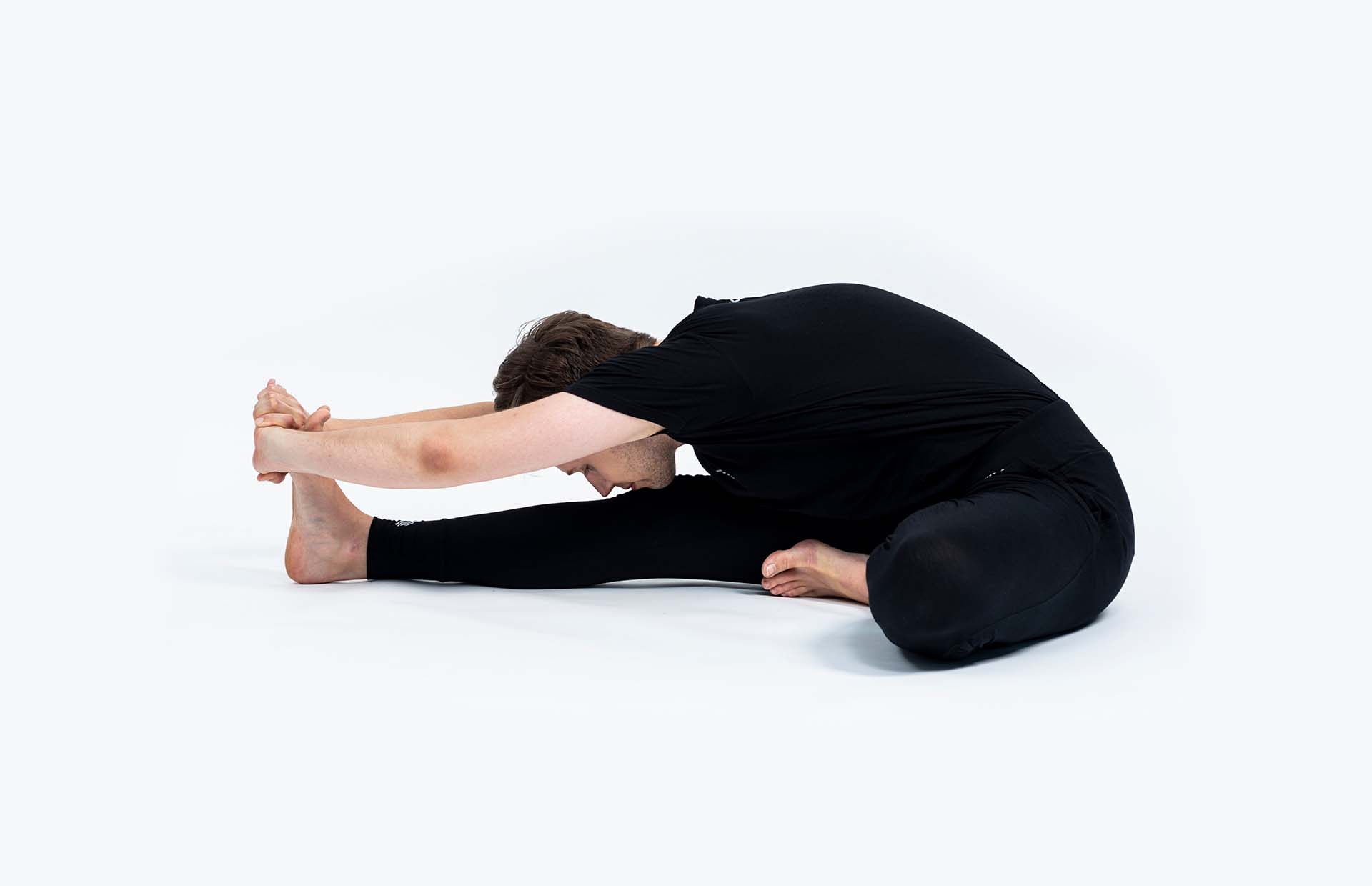 A person bending into Janu Shirshasana (Head-to-Knee Pose)