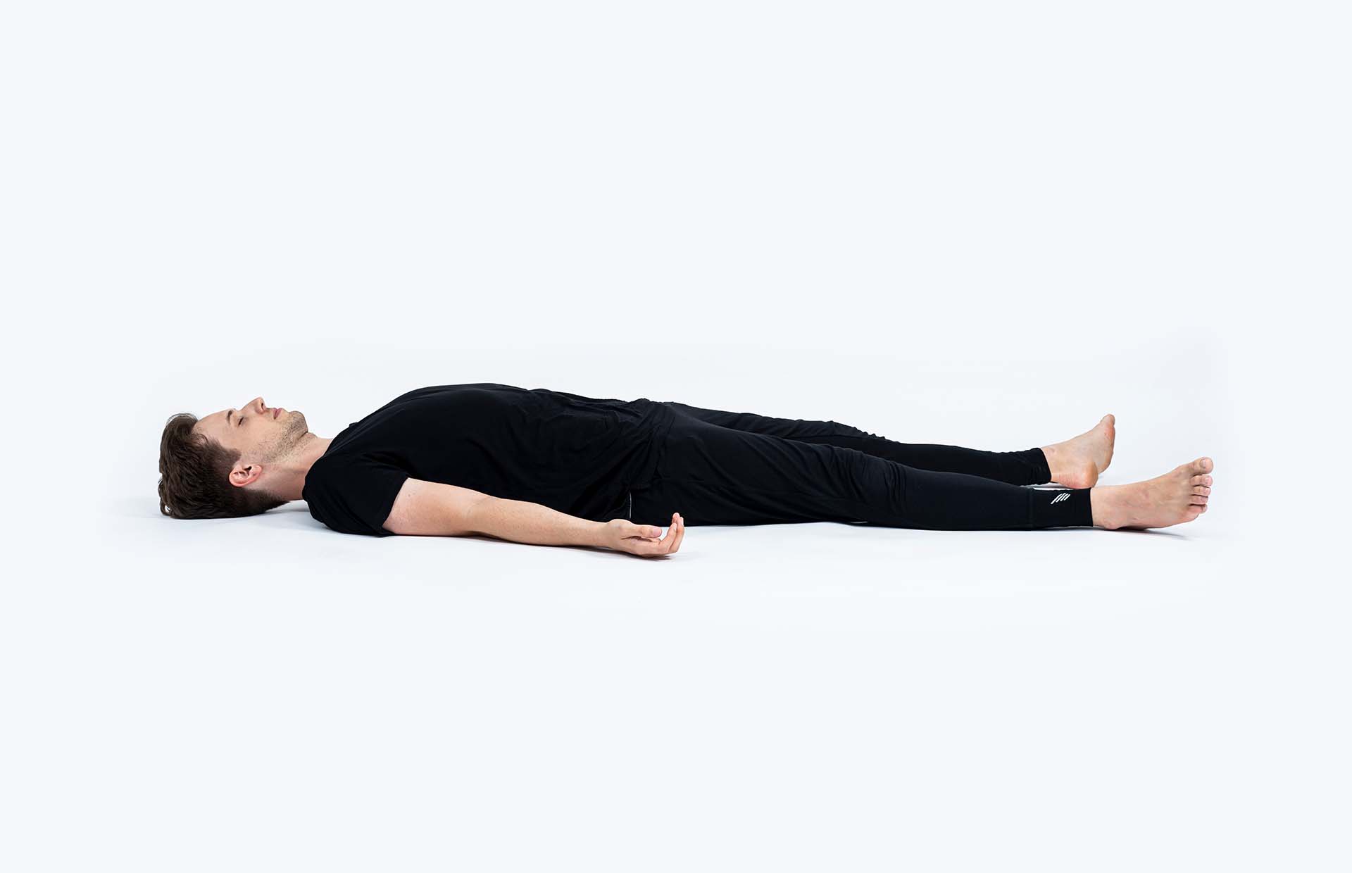 A person laying in Shavasana (Corpse Pose)